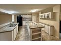 Spacious kitchen with modern white appliances, center island, and ample cabinet space at 4861 Myrtle View N Dr, Mulberry, FL 33860