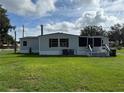 Rear exterior of house with well-maintained lawn and a screened-in porch at 4861 Myrtle View N Dr, Mulberry, FL 33860