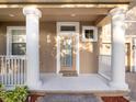 Close-up of the front porch featuring stately columns and a glass-paneled front door at 10084 Moss Rose Way, Orlando, FL 32832