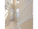 Bright foyer with tiled floor, staircase, and front door with glass insert at 852 Desert Mountain Ct, Reunion, FL 34747