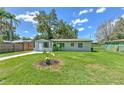 View of the home's front yard with a garden and healthy green grass at 475 W Ethelene St, Bartow, FL 33830