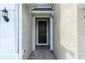 Covered entryway featuring a dark brown front door and brick-paved walkway at 1143 Presidential Ln, Apopka, FL 32703