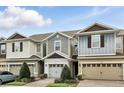 Exterior shot of townhomes featuring attached garages, neutral colors, and well-maintained landscaping at 1143 Presidential Ln, Apopka, FL 32703