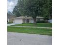Charming single story home with an attached garage and mature trees in the front yard at 204 Madison St, Minneola, FL 34715