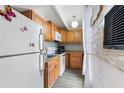 Efficient kitchen featuring wood cabinets, white appliances, and a stylish backsplash at 4711 Club Cir, Lakeshore, FL 33854