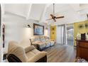 Cozy living room with vaulted ceilings, a ceiling fan, and sliding glass doors to the lanai at 4711 Club Cir, Lakeshore, FL 33854