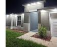 A well-lit home showcasing a walkway and manicured garden area at the front entrance at 10090 Se 67Th Ter, Belleview, FL 34420