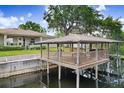 Waterfront property featuring a covered wooden dock with space for outdoor seating and boat access at 93 Bream St, Haines City, FL 33844