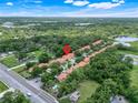 Aerial view showcasing townhomes with red tile roofs, surrounded by lush greenery and community amenities at 2256 Wekiva Village Ln, Apopka, FL 32703