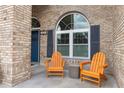 Inviting front porch features a brick facade, arched windows, and comfortable seating, perfect for relaxing at 2423 Turnberry Dr, Oviedo, FL 32765