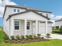 Stylish two-story home with covered porch, two-car garage, and manicured landscaping at 2199 Broadbrook Drive, St Cloud, FL 34771