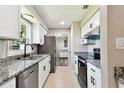 Modern kitchen featuring granite countertops, stainless steel appliances, and sleek white cabinets at 2902 Wheeler St, Bartow, FL 33830