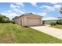 Detached one car garage, set back from the home with a paved driveway and grassy side yard at 3235 Grand Pines Dr, Lakeland, FL 33810