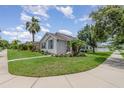 Well-maintained home boasts lush landscaping, enhancing curb appeal with a beautiful, sunny sky above at 3321 Pintello Ave, New Smyrna Beach, FL 32168