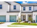 Exterior of townhome featuring a colorful garage door, a tidy walkway, and manicured lawn leading to the inviting front door at 781 Poppy Ln, Dundee, FL 33838