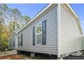 Gray home exterior showcasing horizontal siding, trimmed windows, and an elevated foundation at 40144 Camphor Rd, Lady Lake, FL 32159