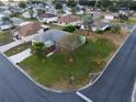 Aerial view of a well-maintained home with a manicured lawn in a peaceful neighborhood with mature trees at 1074 Canary S Cir, Lakeland, FL 33809