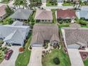 Birds-eye view of a residential home and neighborhood with manicured lawns and mature landscaping at 879 Astor Way, The Villages, FL 32162