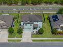 Aerial view of a charming home boasting a well-manicured lawn, fenced yard, and attached two car garage at 5660 Elsinore Way, Lakeland, FL 33805