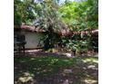 Backyard view with green space and chairs, shaded by trees, offering a tranquil outdoor retreat at 6615 New Tampa Highway, Lakeland, FL 33815