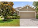 Exterior home shot highlighting the neutral color scheme, lush landscaping and a 2 car garage at 1111 Bassano Way, Orlando, FL 32828