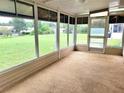 Enclosed sunroom boasts panoramic views of the large yard and outdoor greenery at 8386 Sw 105Th Pl, Ocala, FL 34481