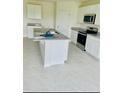 Bright kitchen featuring white cabinetry, granite countertops, and stainless steel appliances at 5543 Siltstone St, Lakeland, FL 33811