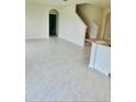 Spacious living room featuring tile flooring, an open layout, and a view of the staircase and bathroom at 5543 Siltstone St, Lakeland, FL 33811