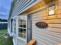 Close-up of the home's exterior showcasing the house number, siding, window, and outdoor lighting at 5790 Cherry Tree Dr, Lakeland, FL 33811
