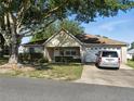 Traditional-style home featuring a brick facade, attached garage, well-maintained lawn, and mature shade trees at 9859 Sw 97Th St, Ocala, FL 34481