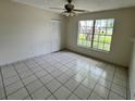 Well-lit bedroom features tile flooring, ample natural light, and a ceiling fan at 299 Cobalt Dr, Kissimmee, FL 34758