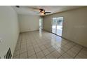 Bright living room with tile flooring, ceiling fan, and sliding glass doors at 299 Cobalt Dr, Kissimmee, FL 34758