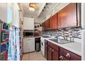 This cozy kitchen features stainless steel appliances, white cabinets and modern backsplash at 523 Club Cir, Lakeshore, FL 33854