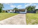 Inviting home showcasing a long driveway and a neat front yard with a picket fence at 811 Casselberry Dr, Lake Wales, FL 33853