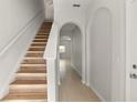 Bright hallway and staircase with arched entryways and neutral colors and tile floors at 1183 Honey Blossom Dr, Orlando, FL 32824