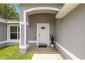 Inviting front entryway with arched doorway and a welcoming 'hello' doormat at 231 Marion Oaks Trl, Ocala, FL 34473