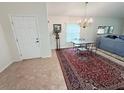 Bright dining area with vintage chandelier, table and chairs, rug, and view into entry at 663 Jamaica Cir, Lakeland, FL 33803