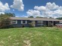 Charming single-story home with gray brick exterior, well-maintained lawn, and a covered carport at 119 Allen Ave, Winter Haven, FL 33880