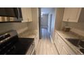 Well-lit kitchen showcases new stainless steel appliances, granite countertops and updated flooring at 1514 Crest Ave, Leesburg, FL 34748