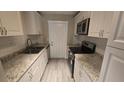 Updated kitchen featuring granite countertops, white cabinets, subway tile backsplash and modern appliances at 1514 Crest Ave, Leesburg, FL 34748