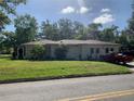 Exterior view of a single-story home with a green lawn and a red pickup truck in the driveway on a sunny day at 550 W Oak Dr, Lakeland, FL 33803