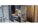 Modern kitchen features stainless steel appliances, dark cabinetry, and stone countertops at 528 Winding Oak Ln, Longwood, FL 32750