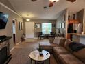 Comfortable living room featuring carpet flooring, a fireplace, and easy access to the kitchen at 2509 Montecito Ave, Eustis, FL 32726