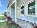 Covered front porch with brick flooring, white columns, and tasteful landscaping along the walkway at 198 Gypsy Palace Ln, Daytona Beach, FL 32124
