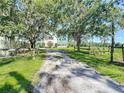 Long driveway leading to a charming home with mature trees and rustic accents at 10222 Rockridge Rd, Lakeland, FL 33810