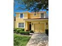 Charming two-story yellow home featuring a red tile roof, and a well-manicured lawn at 8923 Cuban Palm Rd, Kissimmee, FL 34747