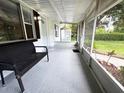 Covered screened porch with seating and neutral epoxy flooring at 1400 E Fern Rd, Lakeland, FL 33801