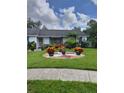 Well-manicured front yard featuring decorative landscaping, plantings, and bench at 7607 Benji Ridge Trl, Kissimmee, FL 34747