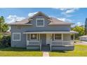 Charming two-story home featuring a welcoming front porch and landscaped lawn at 1048 W Lime St, Lakeland, FL 33815