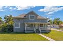 Inviting two-story home featuring a classic facade, front porch, and a lush green lawn at 1048 W Lime St, Lakeland, FL 33815